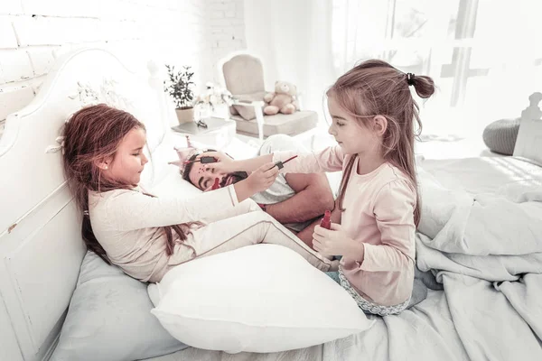 Sleeping dad has his face painted by his daughters — Stock Photo, Image