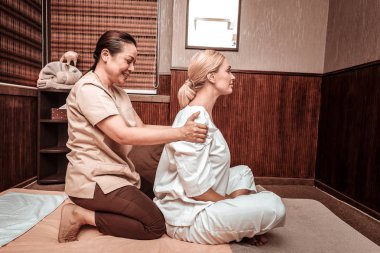 Masaj salonunda müşterisine masaj gülümseyen kadın.