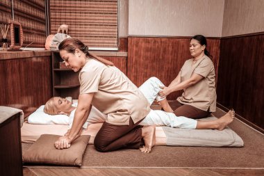 Kadın el ve bacak masajı oluyor.