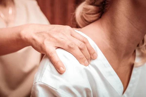 Massagem nas costas para uma mulher bonita cansada . — Fotografia de Stock