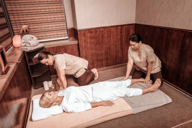 İki kadın müşterileri için masaj yapıyor.