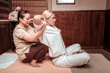 Masöz müvekkilinin onu sırtından sarkıntArına yardım ediyor..