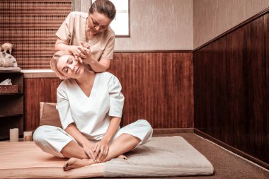 Özel boyun masajı yaptıran sakin kadın.