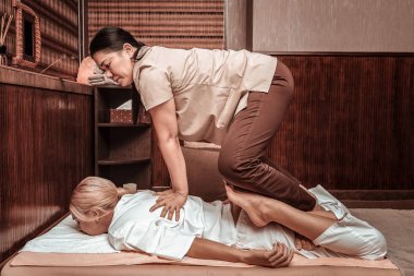 Kadın güçlü masöz ile otantik tay masajı alıyorum.