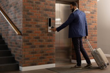 Asansör bekleyen mutlu sakallı erkek kişi