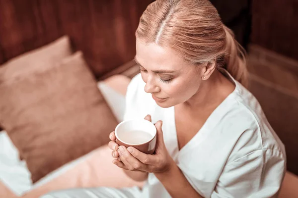 Mujer cerrando los ojos oliendo su té verde . — Foto de Stock