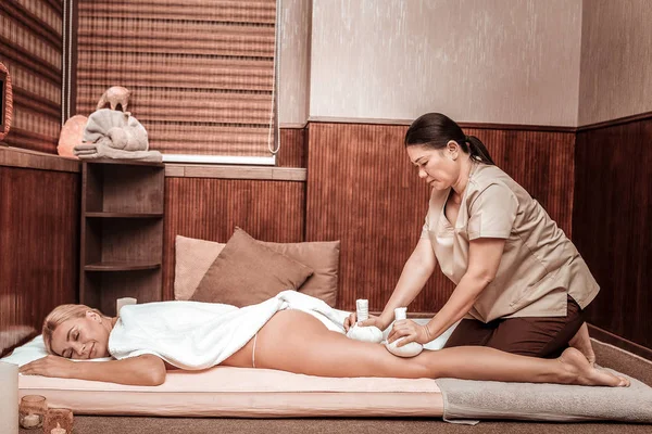 Vrouw ontspannen tijdens haar hippe massage met tassen. — Stockfoto