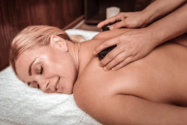 Hermosa mujer disfrutando de su masaje de piedra caliente . —  Fotos de Stock