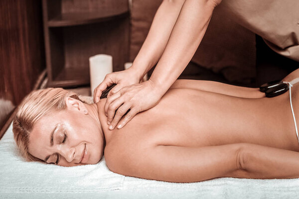 Женщина получает массаж после горячих камней
.