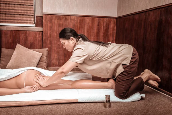 Masażysty robi pośladki masaż dla jej klient. — Zdjęcie stockowe