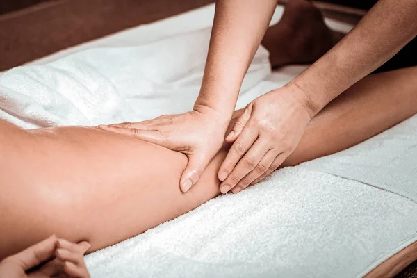 Masseuse doing oil massage of clients hips. — Stock Photo, Image