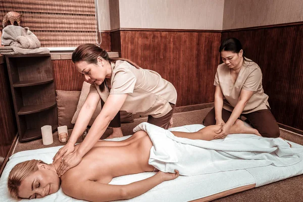 Due donne che fanno massaggio all'olio nel salone di massaggio . — Foto Stock