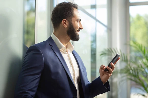 Vrolijke jonge brunette man kijkt naar venster — Stockfoto