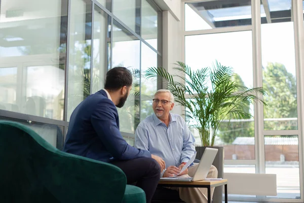 Alegre hombre de pelo gris consultando con empresario progresista — Foto de Stock