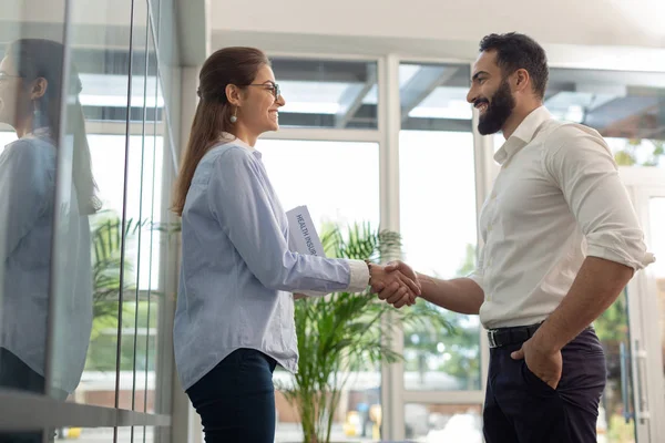 Cheerful bearded male person welcoming new worker