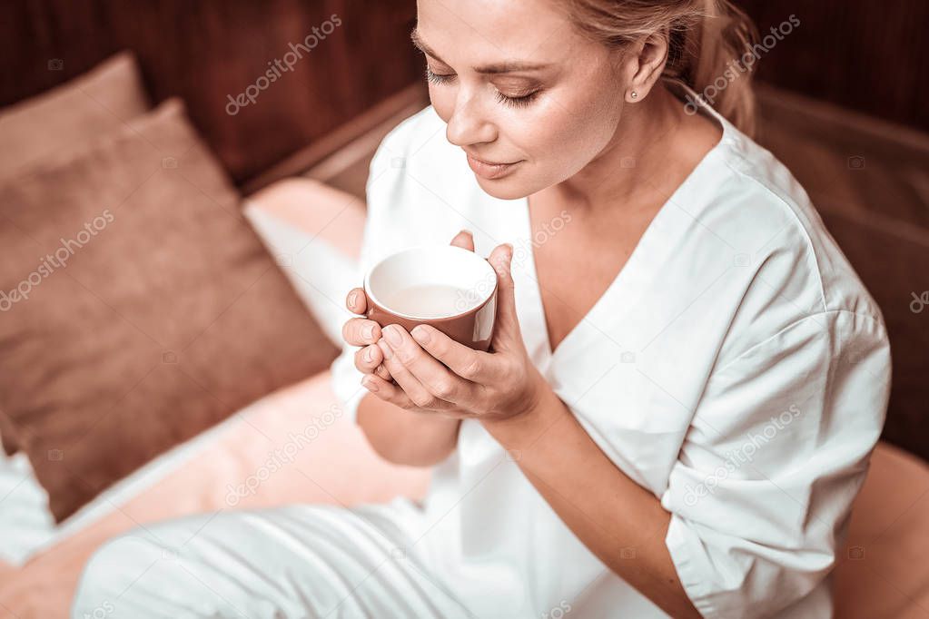 Beautiful woman enjoying the flavour of her tea.