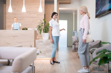 Diş hekimi hastaya nereye gideceğini gösteriyor.