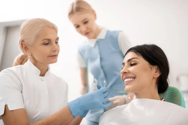 Zahnärztin probiert Zahnweiß-Proben für ihre Patientin. — Stockfoto