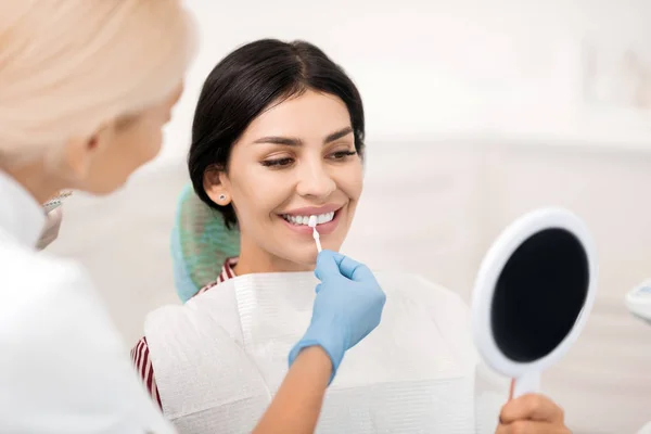 Mulher tentando dentes branqueamento amostra em dentistas . — Fotografia de Stock