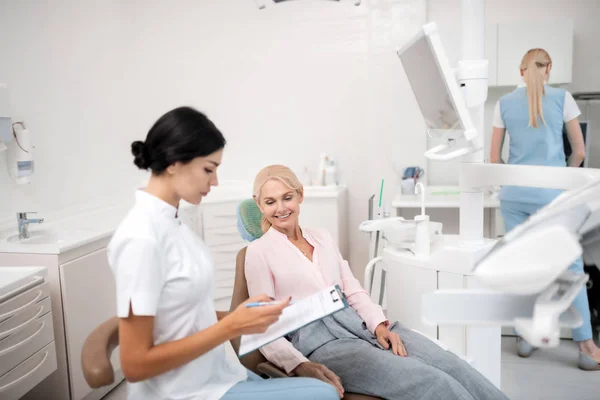 Стоматолог пише інформацію про свого нового пацієнта . — стокове фото