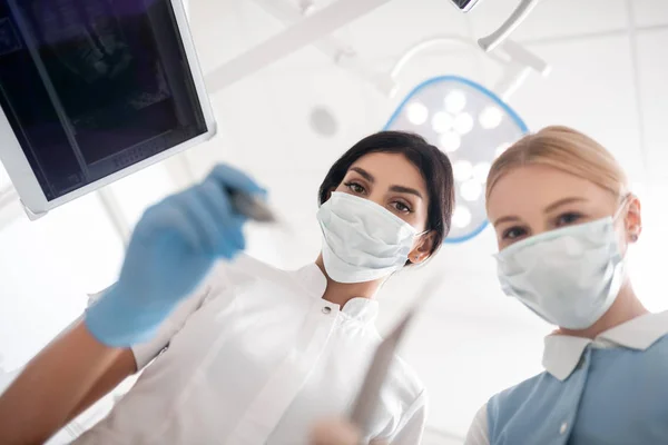 Tandarts en haar assistent beginnen met de operatie. — Stockfoto