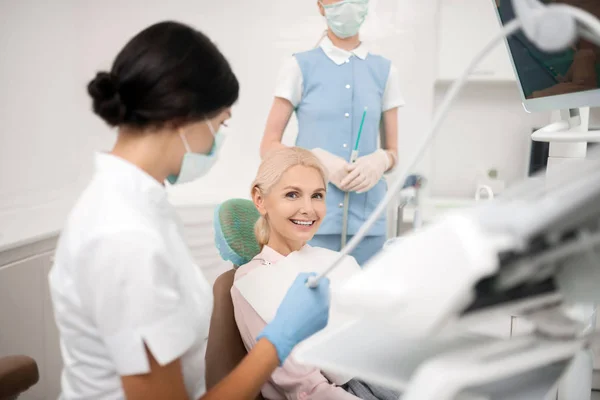 Mulher feliz esperando pelo início de seu tratamento odontológico . — Fotografia de Stock