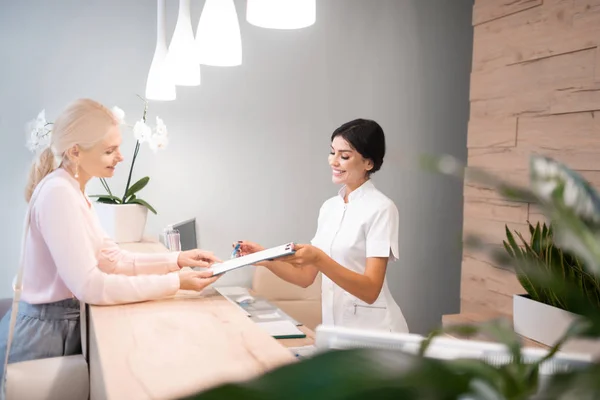 Administrator zeigt dem Kunden, wie er das Formular ausfüllen kann. — Stockfoto