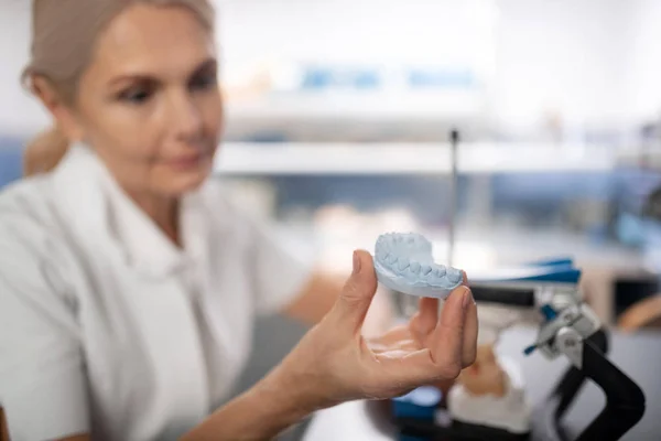 Tandläkare som tittar på patienter gjutna modell av tänder. — Stockfoto