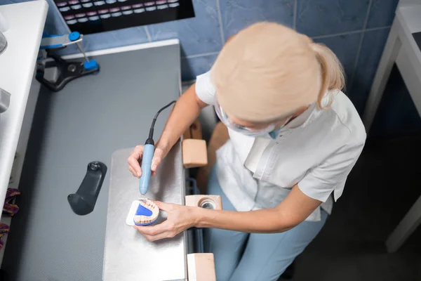 Polieren von Zahnprothesen im Büro des Zahntechnikers. — Stockfoto