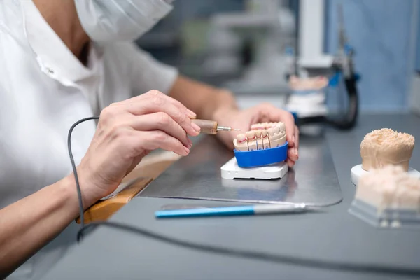 Professionele prothese technicus die tand porselein voor de patiënt maakt. — Stockfoto