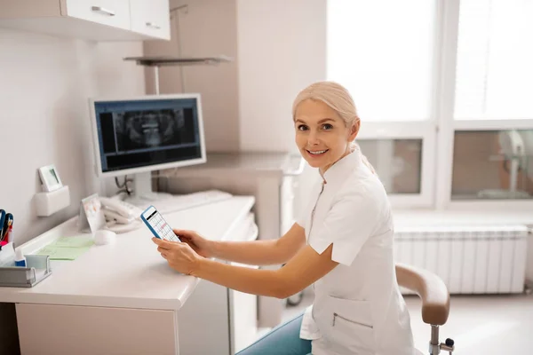 Zahnärztin lächelt ihrem Kunden ins Büro. — Stockfoto