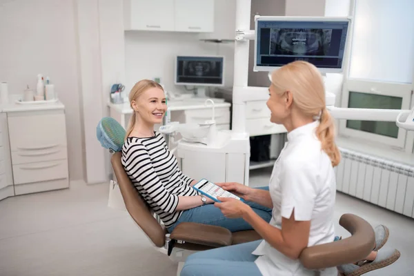 Стоматолог консультує свого пацієнта про майбутні зустрічі . — стокове фото