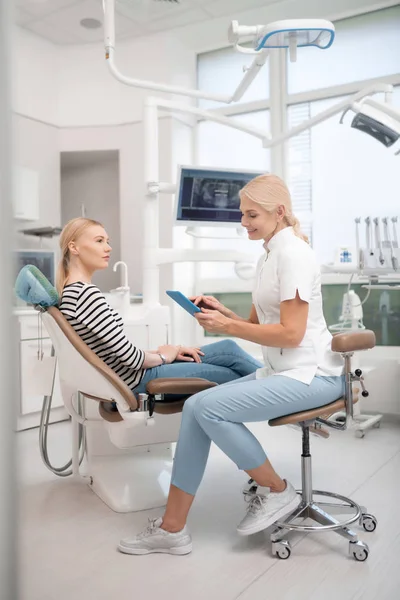 Patiënt vraagt haar tandarts over haar kaak x-ray. — Stockfoto