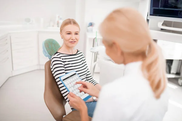 Dentista escolhendo a data da próxima consulta com sua paciente . — Fotografia de Stock