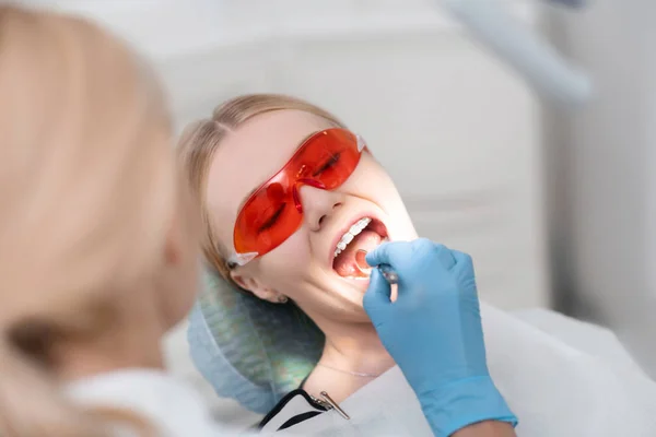 Ung kvinna öppnar munnen under tandundersökning. — Stockfoto