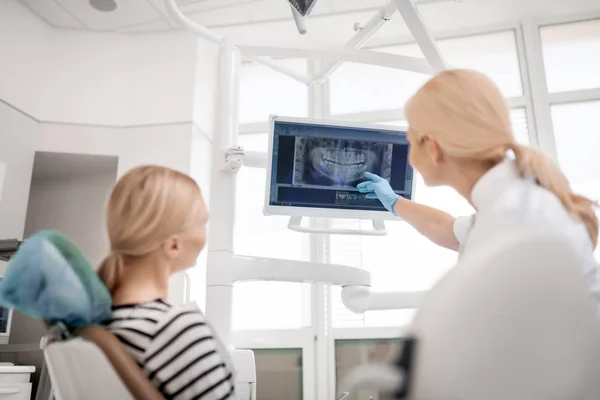 Dentista mostrando grande imagem dos pacientes raio-X da mandíbula . — Fotografia de Stock