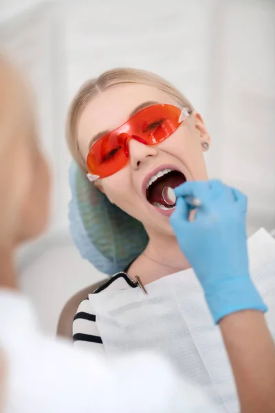 Dentist using dental mirror examining her patient. — Stock Photo, Image