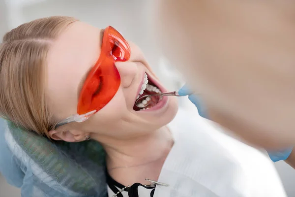 Planned dental examination of young cheerful woman.