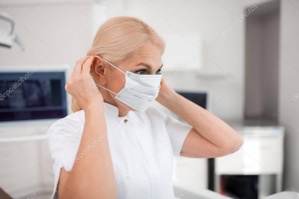 Dentist preparing for treating her new patient.