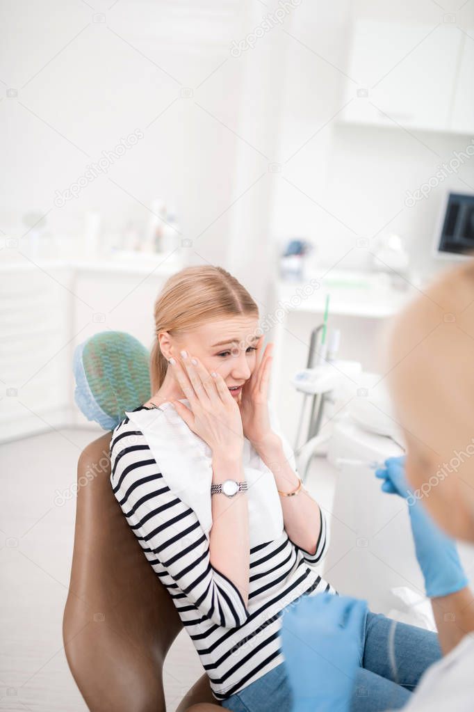 Young woman being afraid of dental treatment.