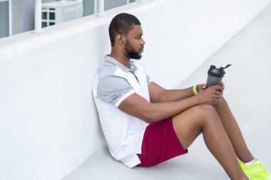 Yakışıklı koyu saçlı genç sporcu mesafe içine bakıyor