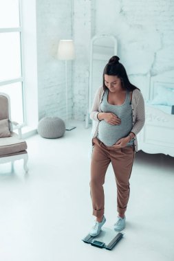 Ağırlıkları üzerinde duran özenli genç hamile kadın