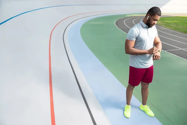 Hombre deportivo afroamericano revisando su rastreador de fitness — Foto de Stock
