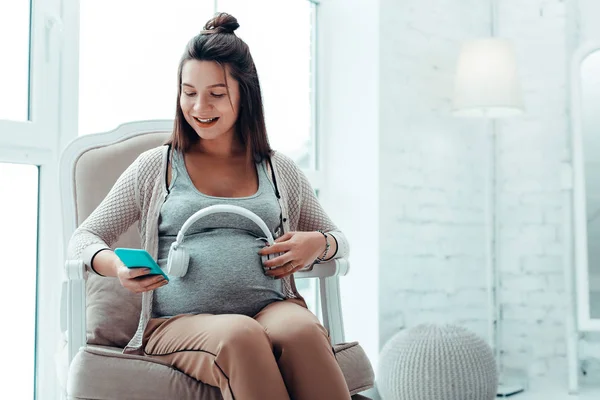 Pretty långhårig kvinnlig stirrade på hennes telefon — Stockfoto