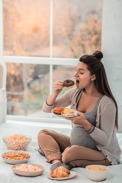 Ziemlich langhaarige weibliche Person genießen süße Donuts — Stockfoto