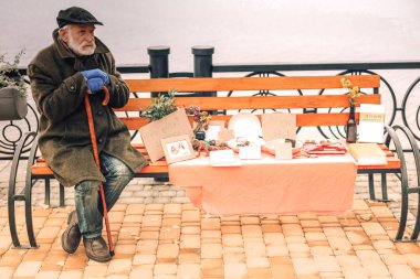 Parkta bir şeyler satan bastonlu yalnız zavallı adam