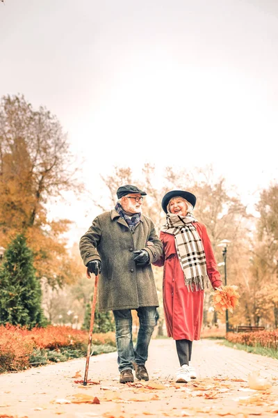 Mari avec canne et femme souriante marchant dans le parc — Photo