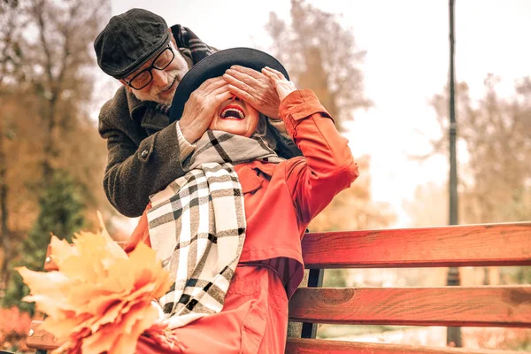 Doce velho surpreendendo sua esposa no parque — Fotografia de Stock