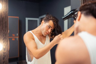 Çekici güzel genç adam saçlarına dokunuyor