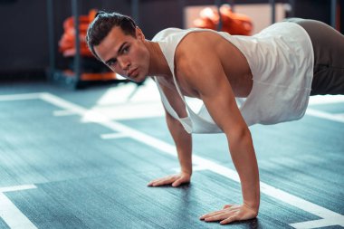 Ciddi iyi inşa edilmiş adam yere ellerini koyarak